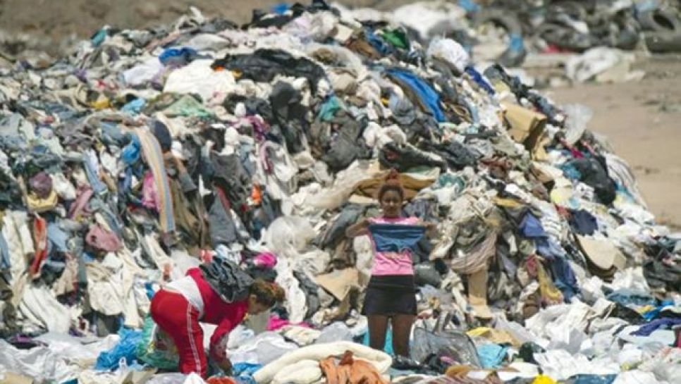 Des personnes cherchent des vêtements usagés dans une décharge sauvage à Alto Hospicio, au Chili, le 26 septembre 2021. © D. R.
