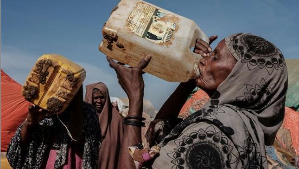 Une femme boit après une distribution d’eau dans le camp de déplacés de Muuri à Baidoa, le 13 février 2022. © D. R.