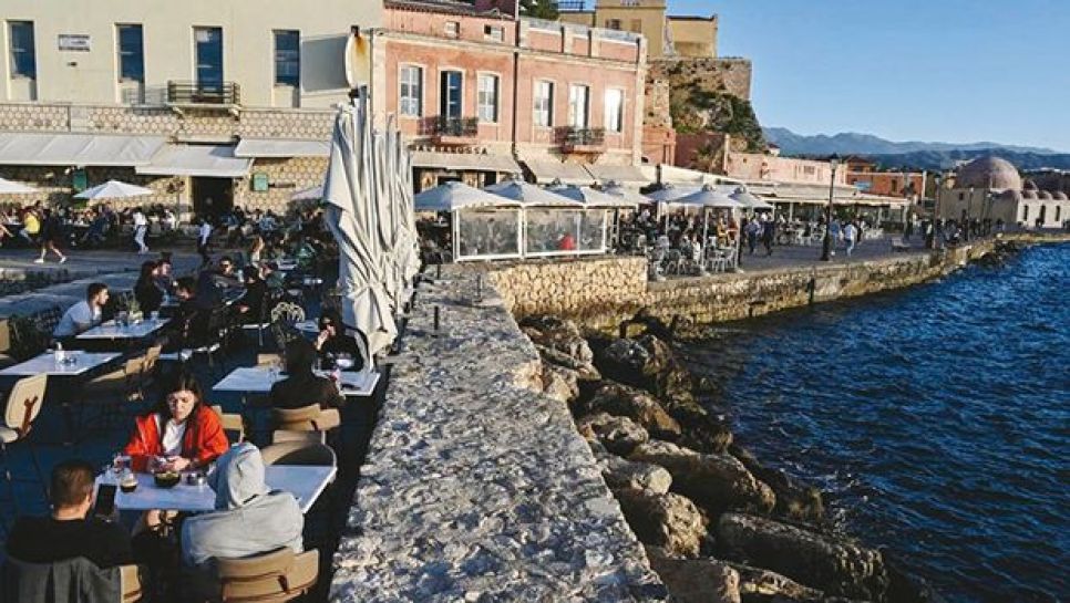 Des jeunes jouent au nouveau jeu de cartes Dopiolalia (qui signifie patois en grec) sur une terrasse de café à Athènes. © D. R.